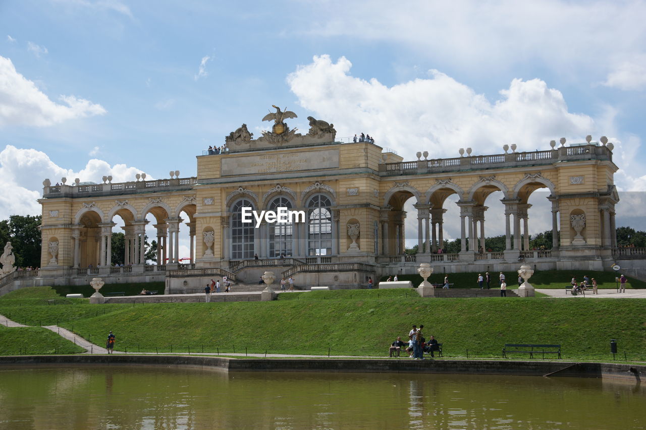 Lake in front of historic building against sky