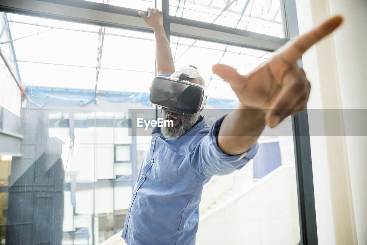 Businessman wearing vr glasses at the window