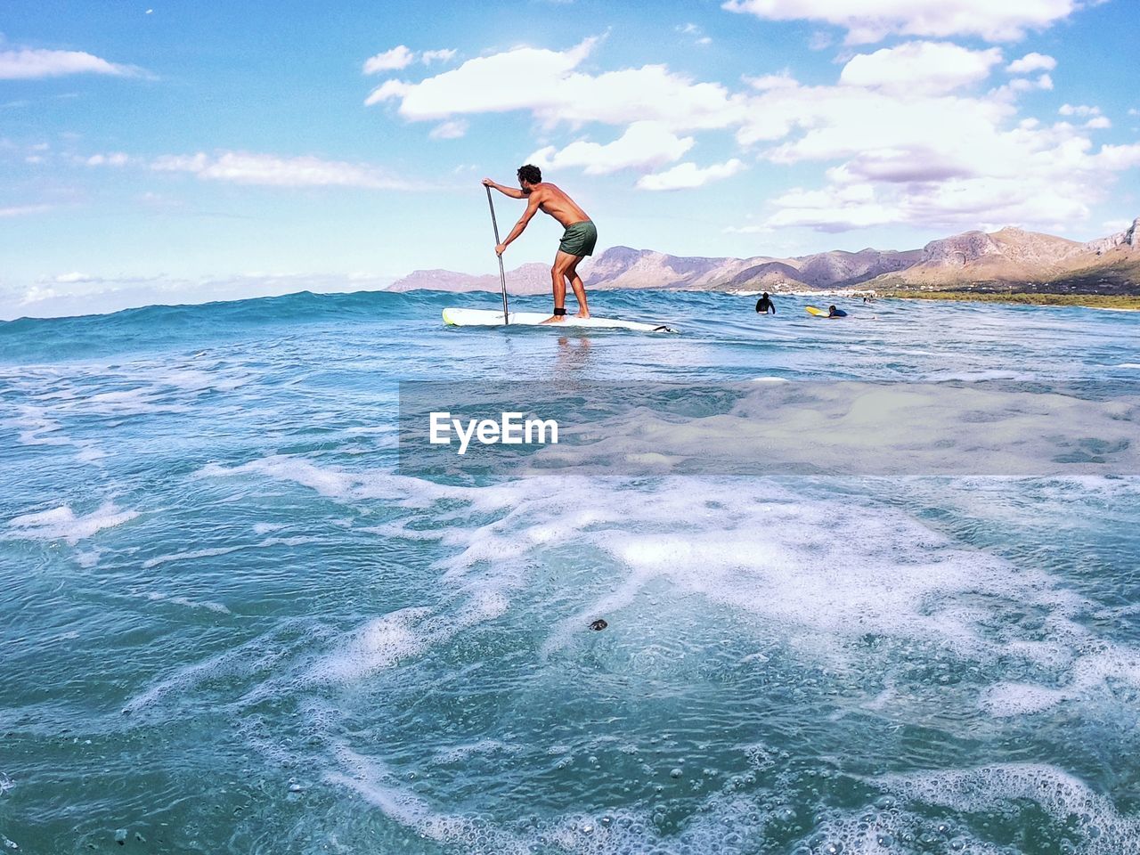 MAN IN SEA AGAINST SKY