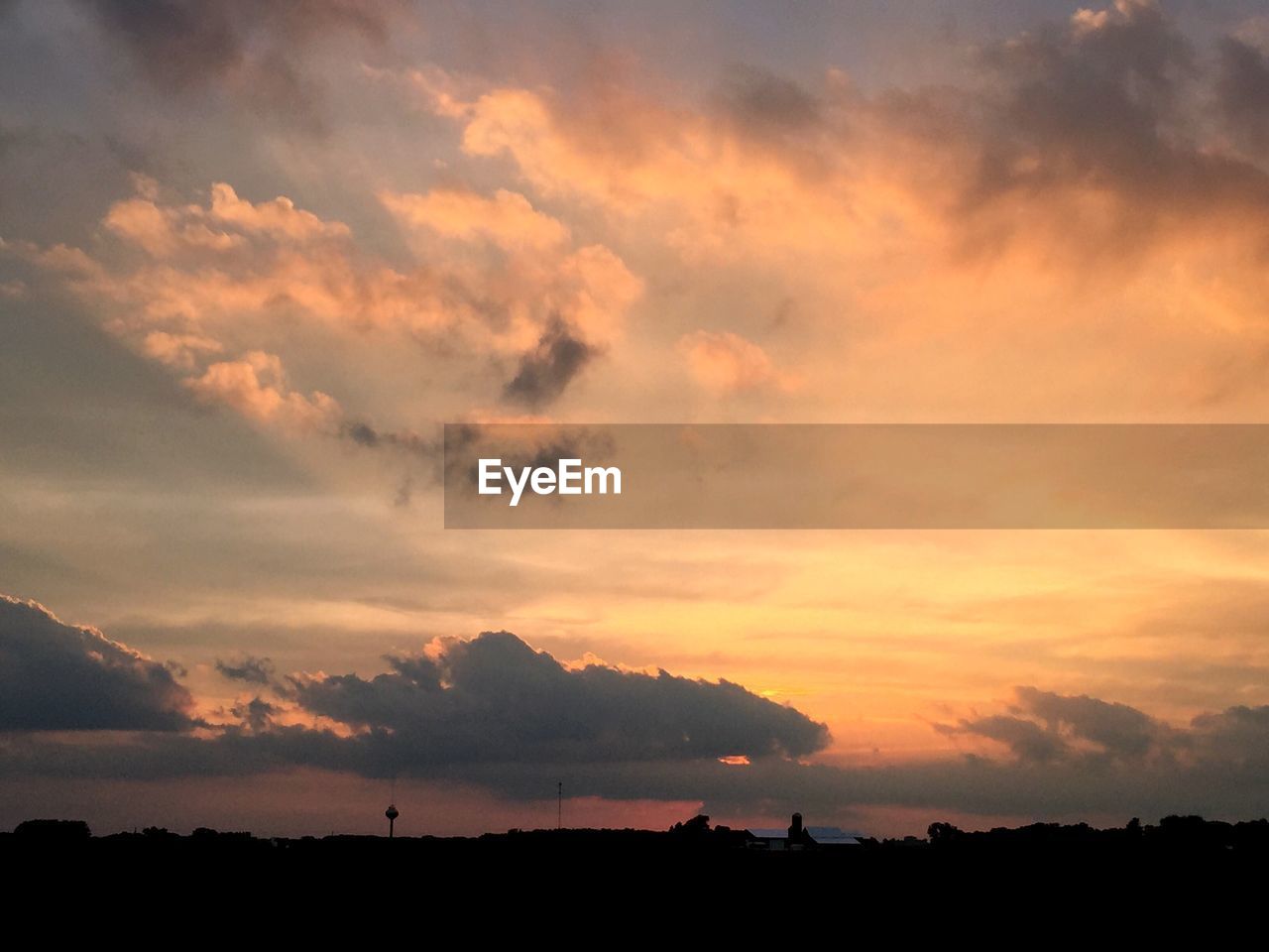 Scenic view of sea against cloudy sky at sunset