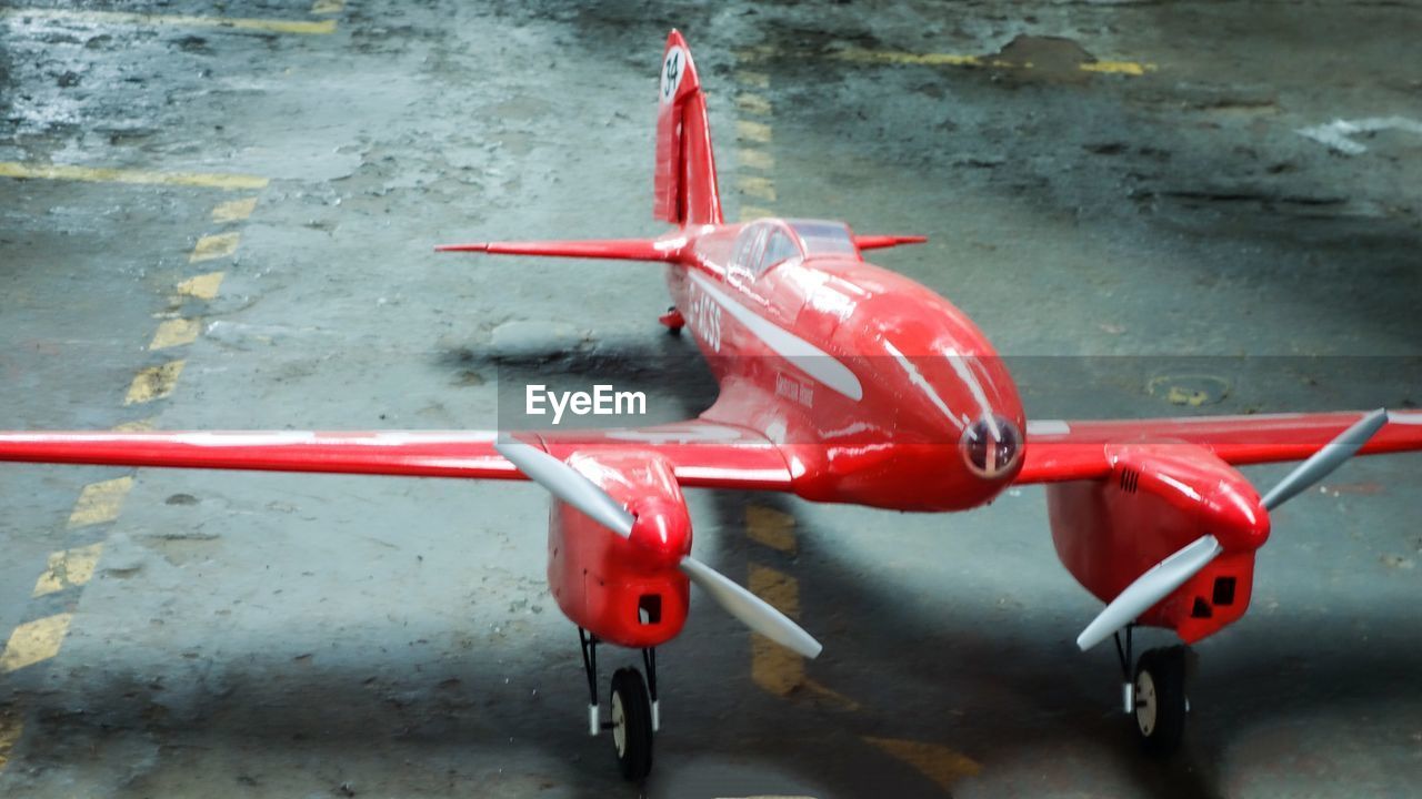 HIGH ANGLE VIEW OF RED AIRPLANE