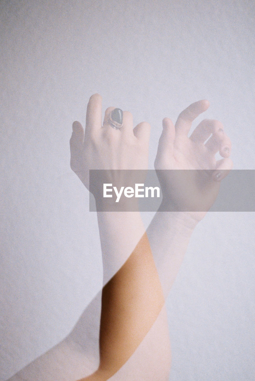 Double exposure of womans hands against white background