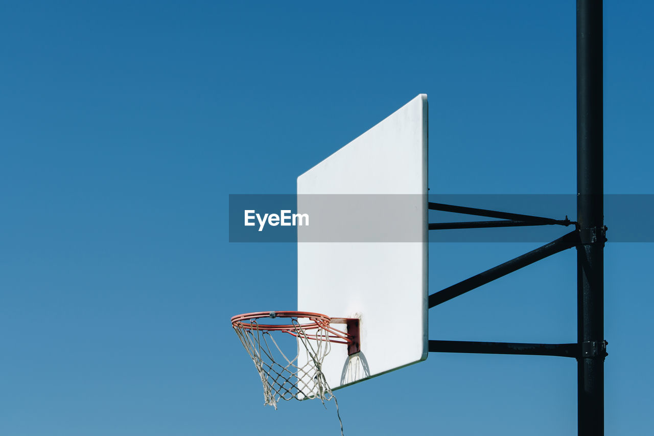 LOW ANGLE VIEW OF BASKETBALL HOOP AGAINST CLEAR SKY