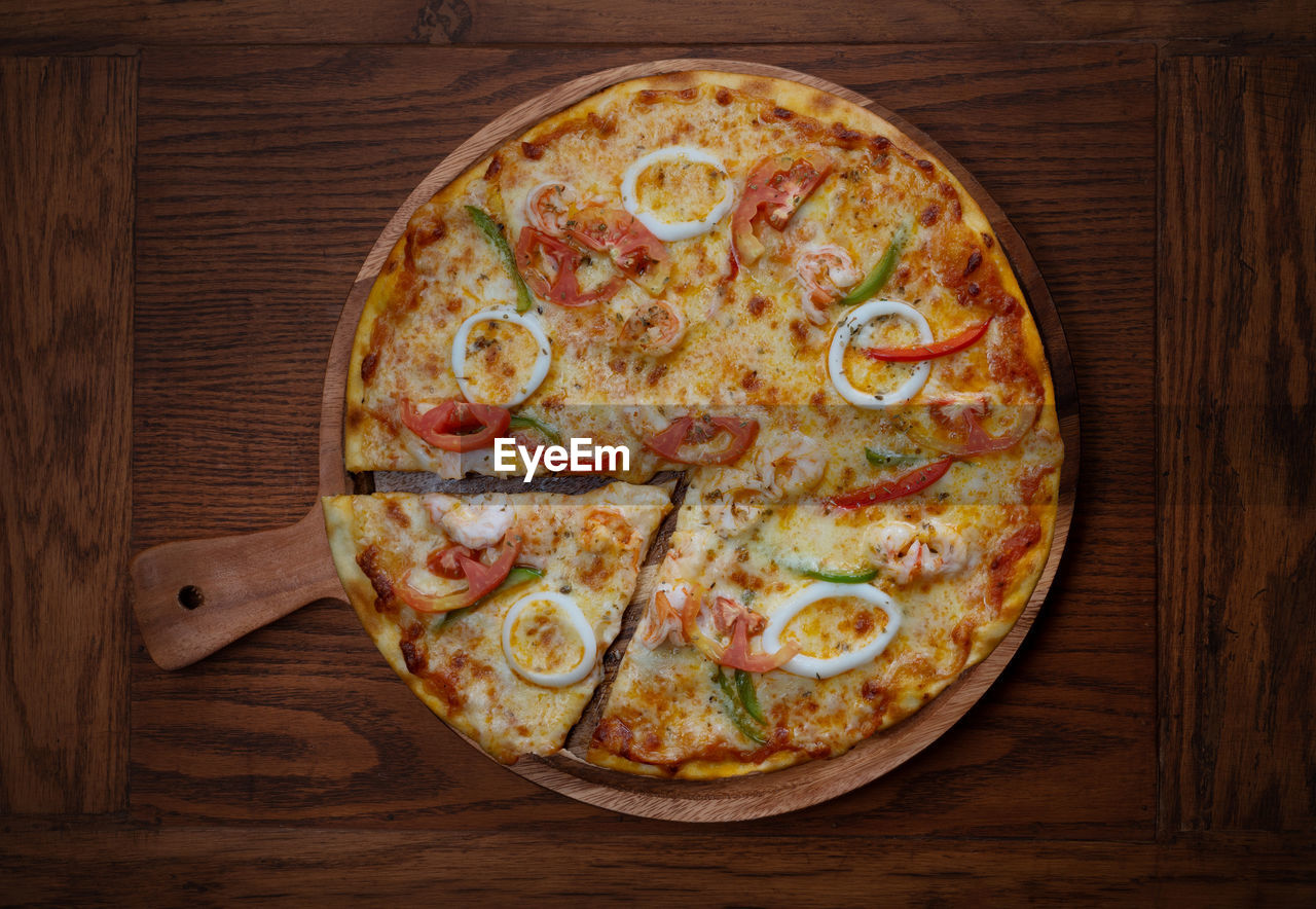 HIGH ANGLE VIEW OF PIZZA ON TABLE AGAINST GRAY BACKGROUND