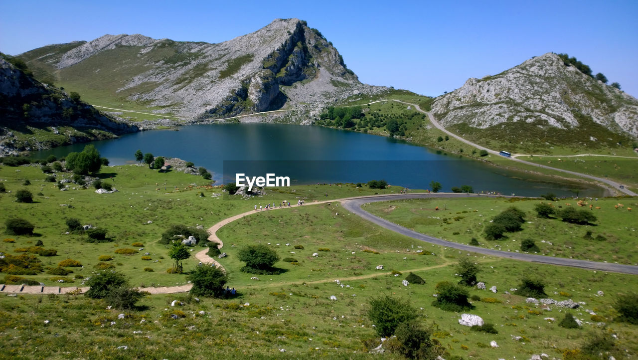 Scenic view of lake and mountains against blue sky