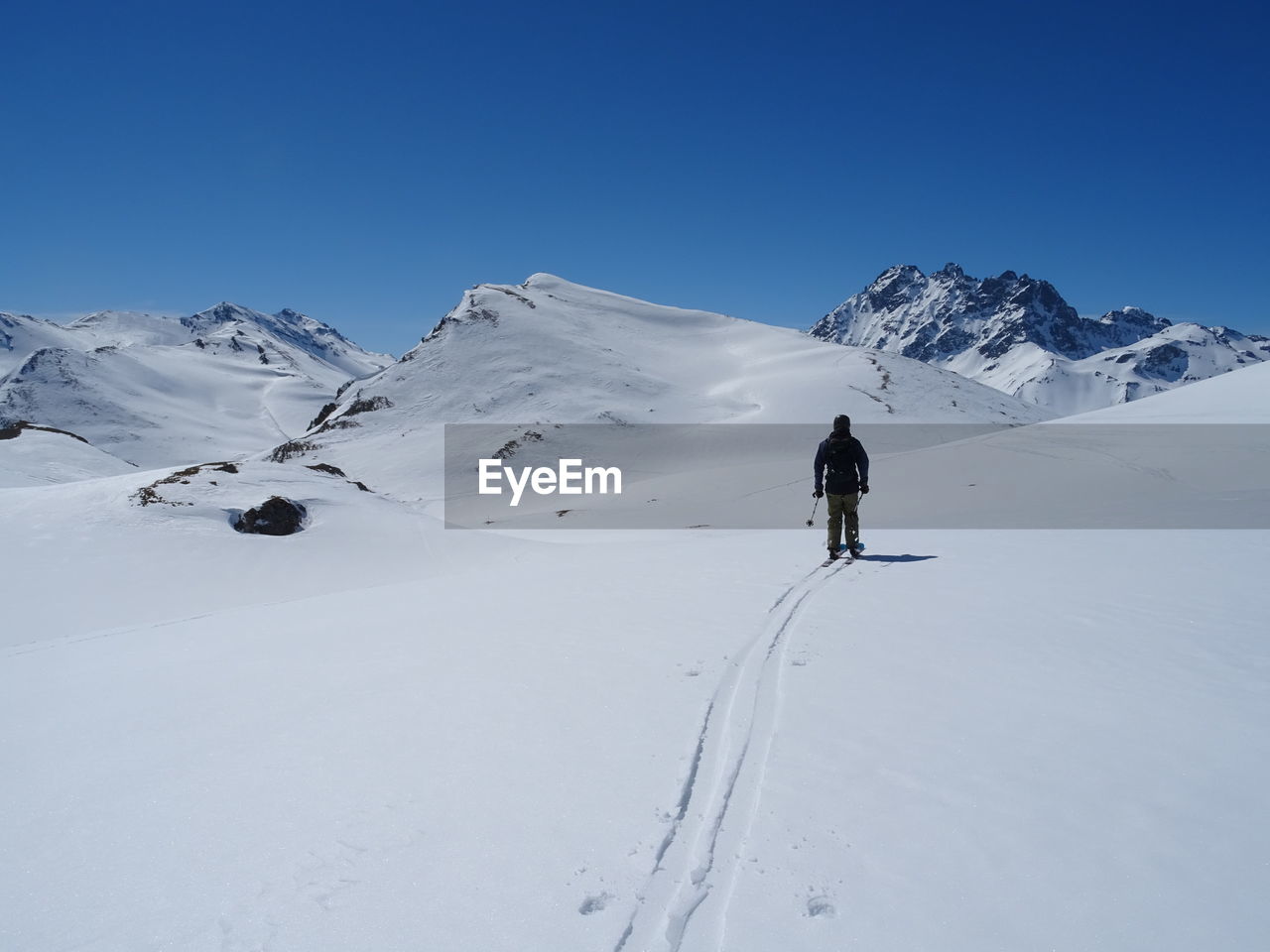 PERSON ON SNOWCAPPED MOUNTAINS AGAINST SKY