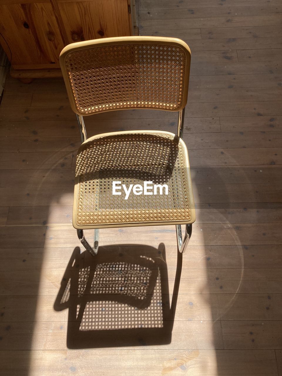 High angle view of empty chair on floor with shadow