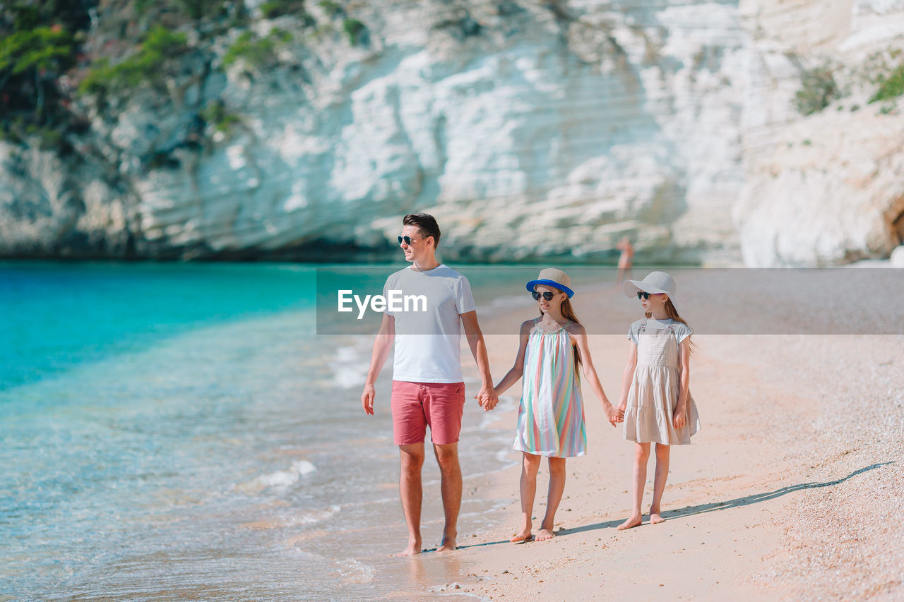 WOMAN STANDING AT BEACH