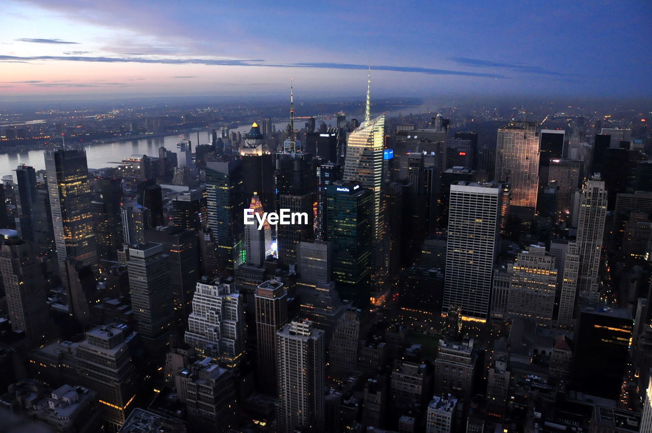 Modern buildings in city against sky at sunset