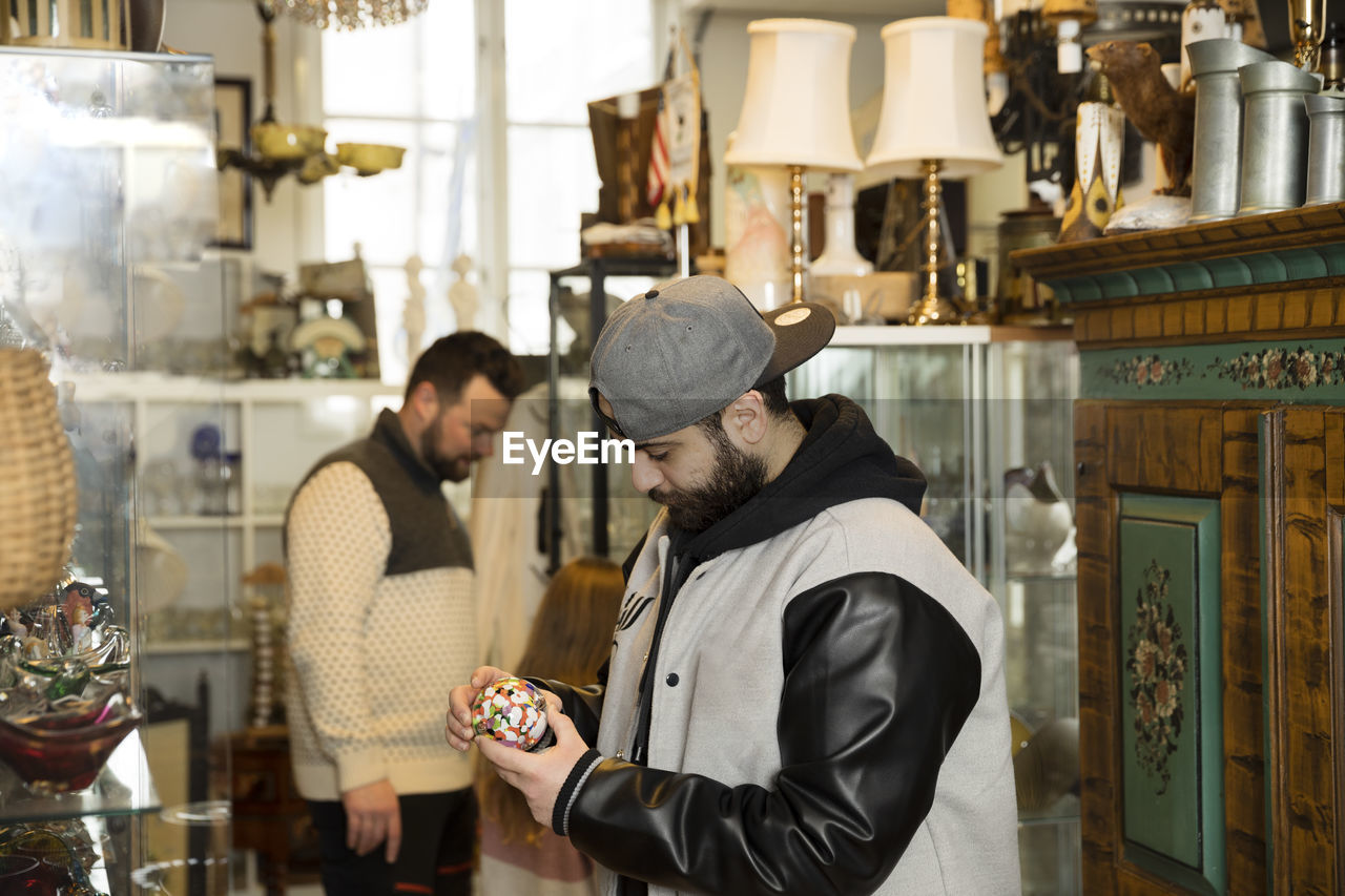 Man checking trinket in antique shop