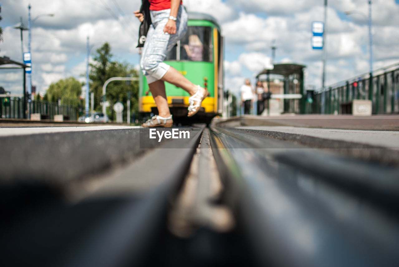 Low section of person crossing railroad track in city