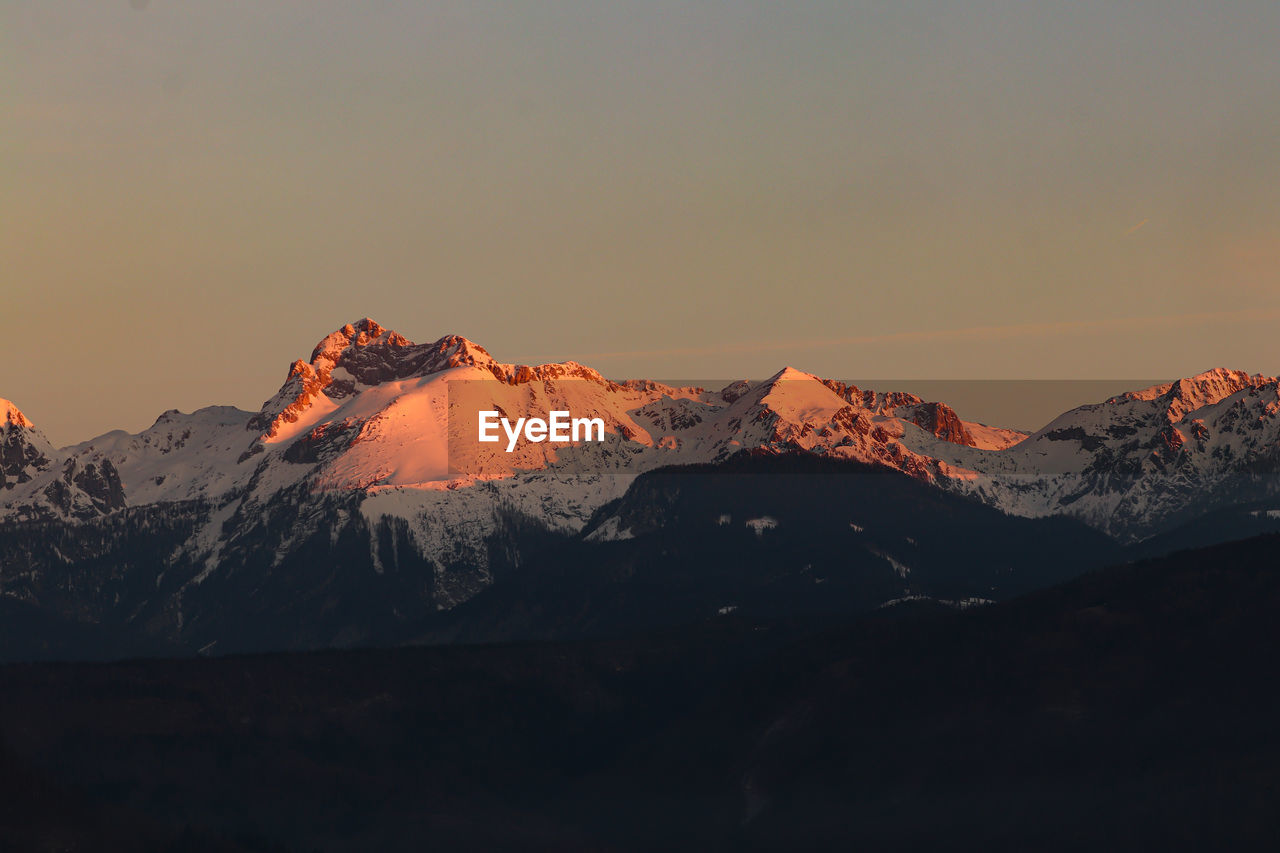 Scenic view of snowcapped mountains against sky during sunset