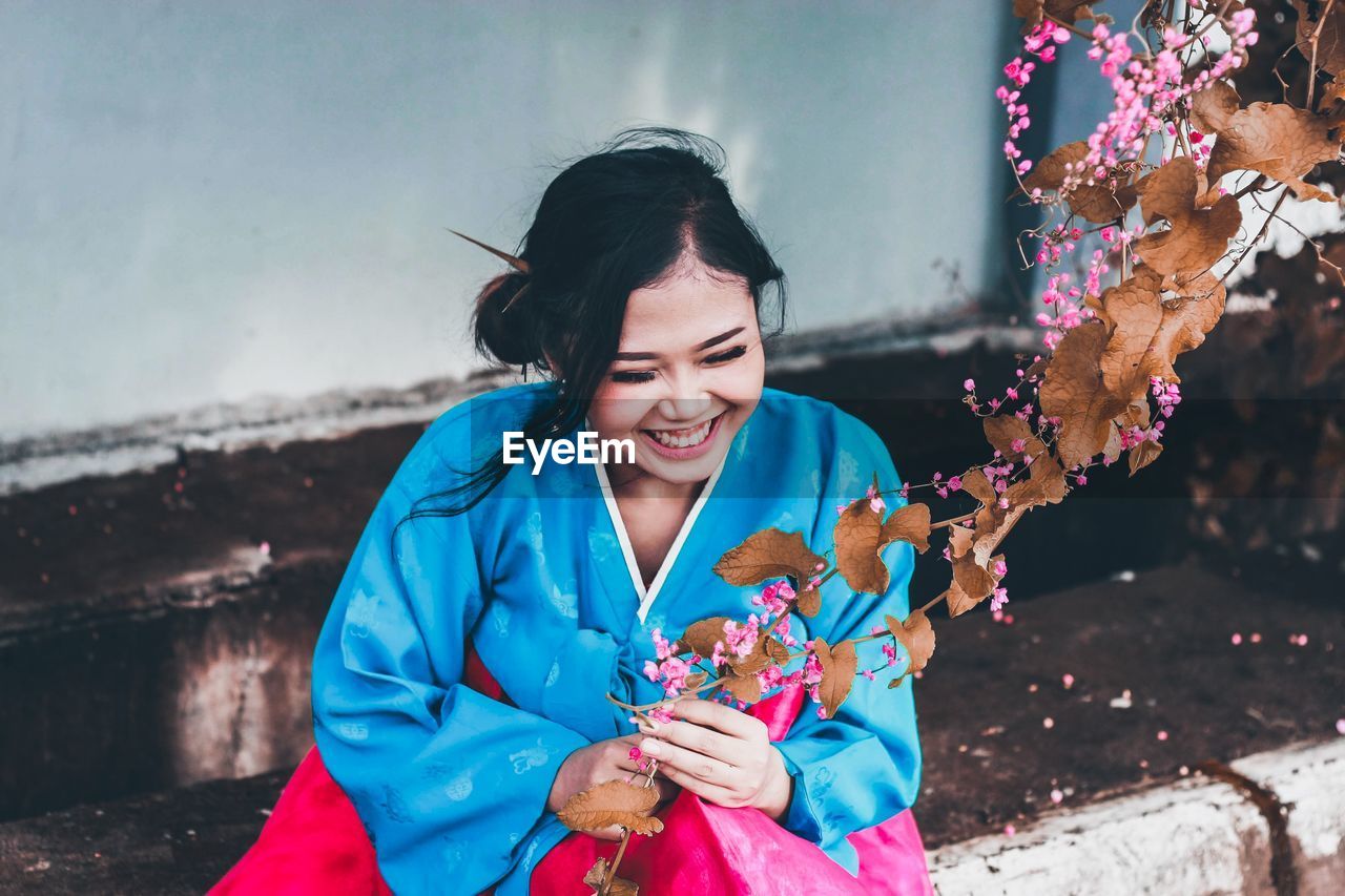 Young woman holding flower outdoors