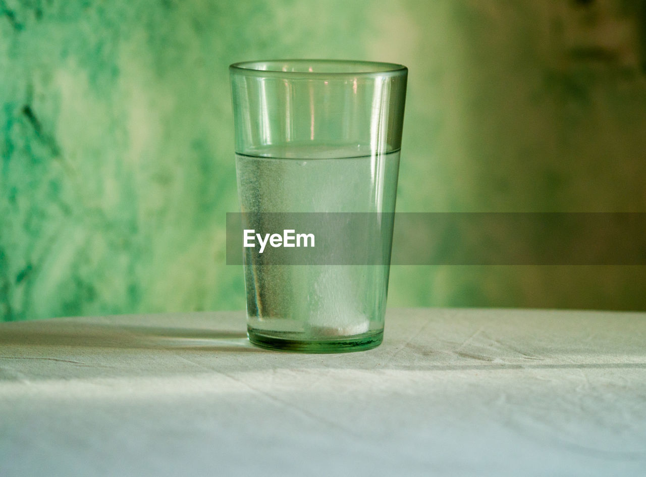 CLOSE-UP OF EMPTY GLASS WITH WATER ON TABLE