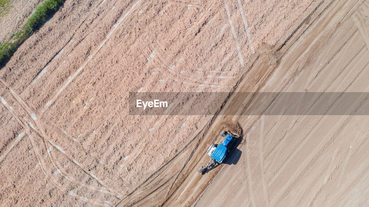 HIGH ANGLE VIEW OF MAN WALKING ON COBBLESTONE STREET