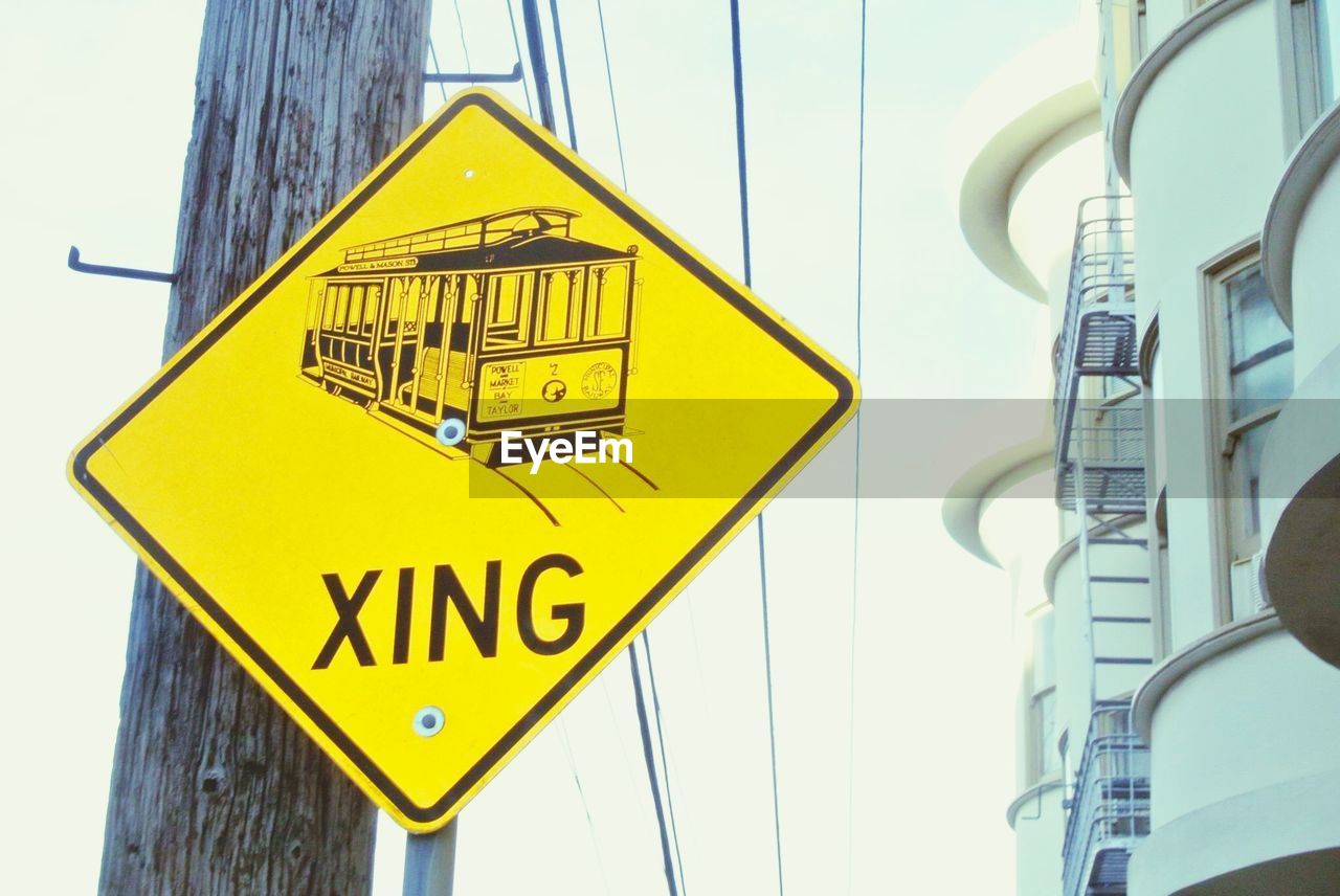 Low angle view of sign board by building against sky