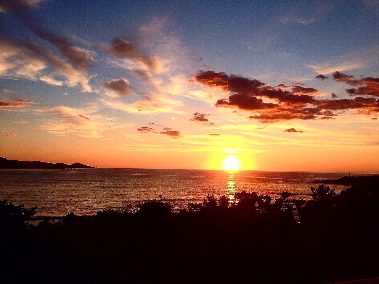 Scenic view of sea against dramatic sky during sunset