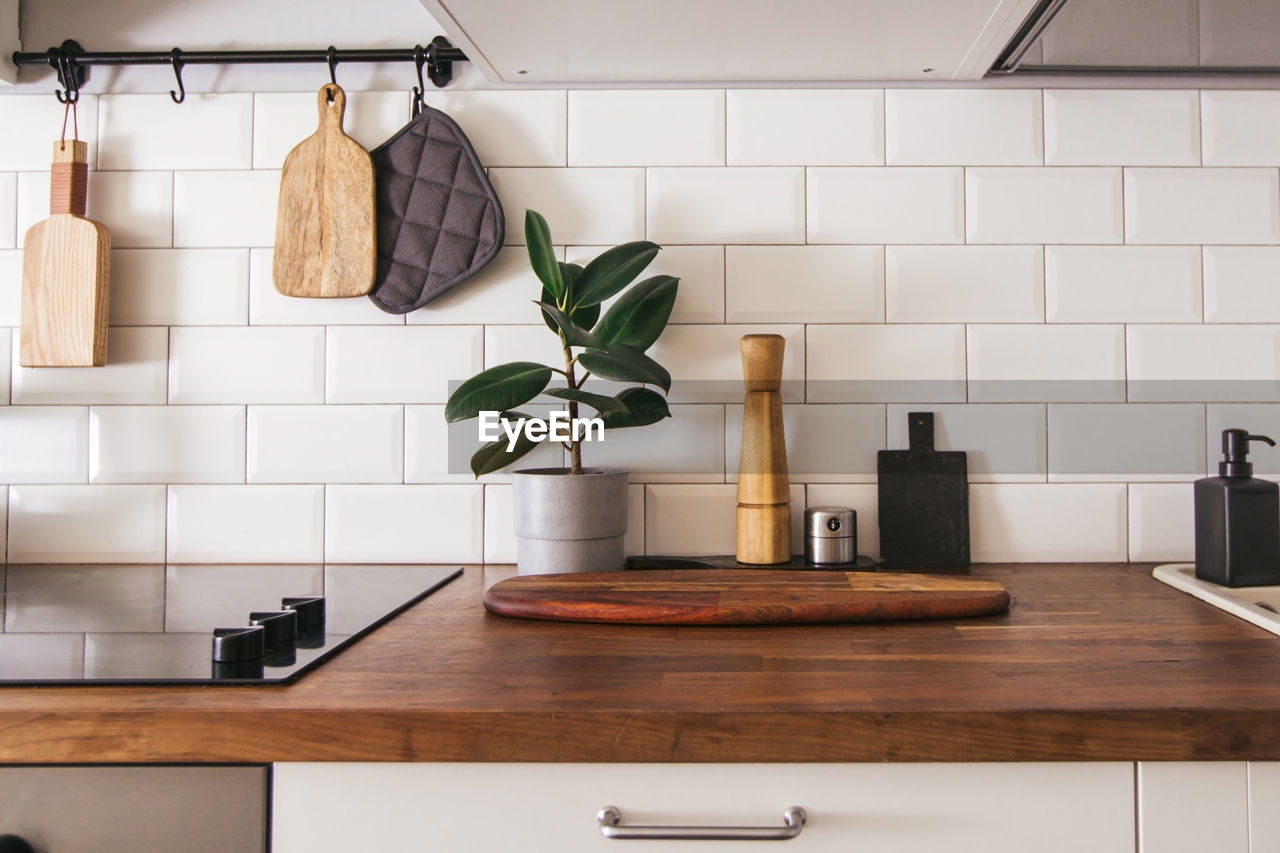 Kitchen brass utensils, chef accessories. hanging kitchen with white wall and wood tabletop.