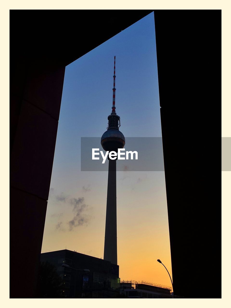 View of communications tower through doorway at sunset