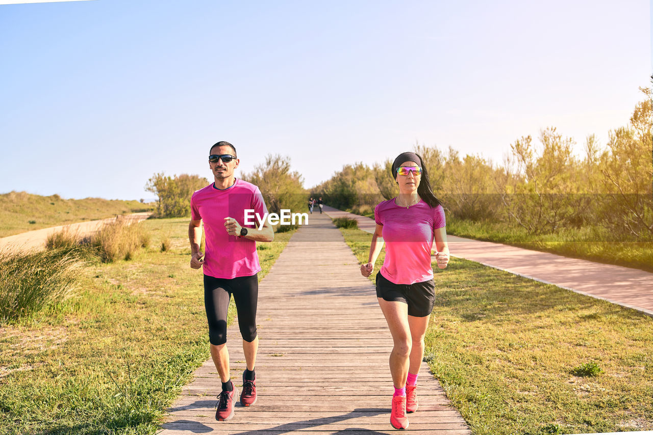 Fit couple running towards camera