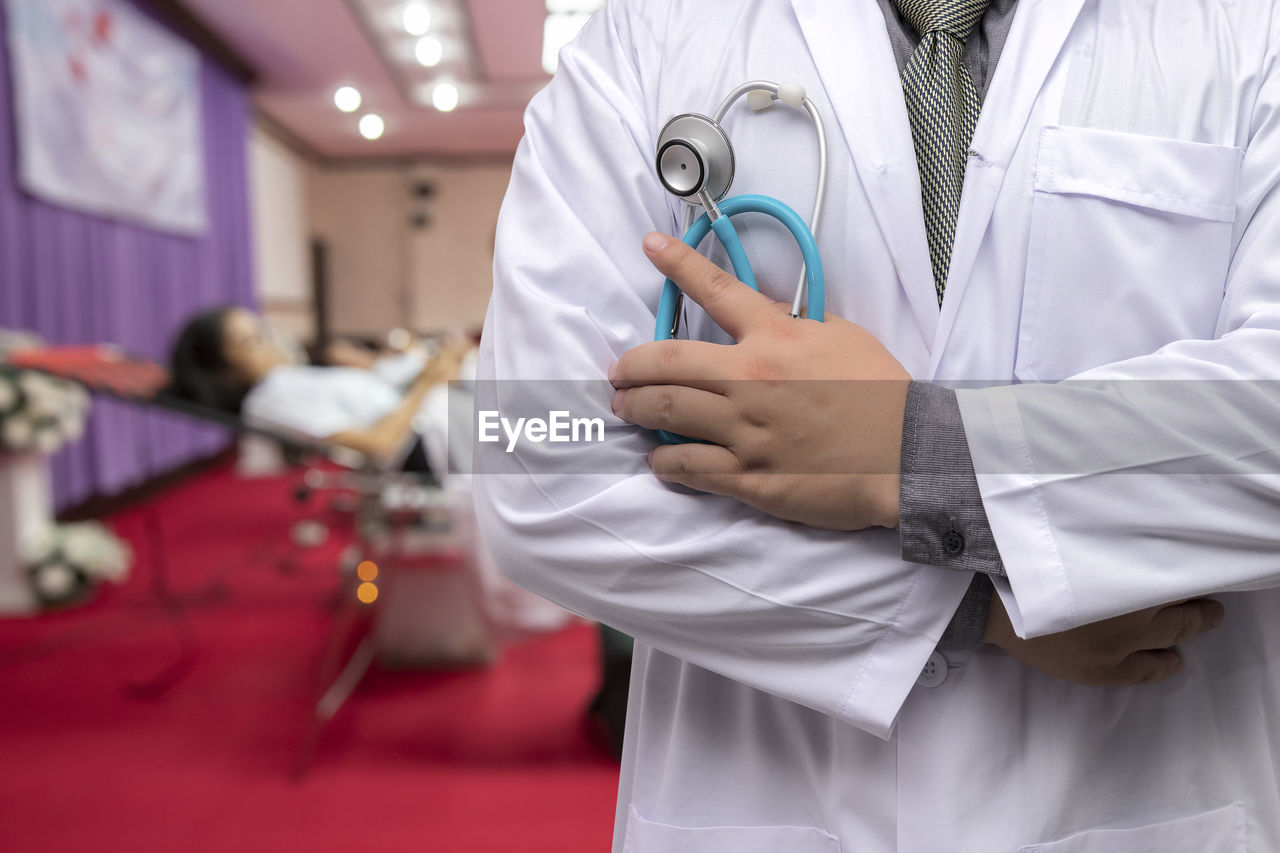 midsection of doctor examining patient in hospital