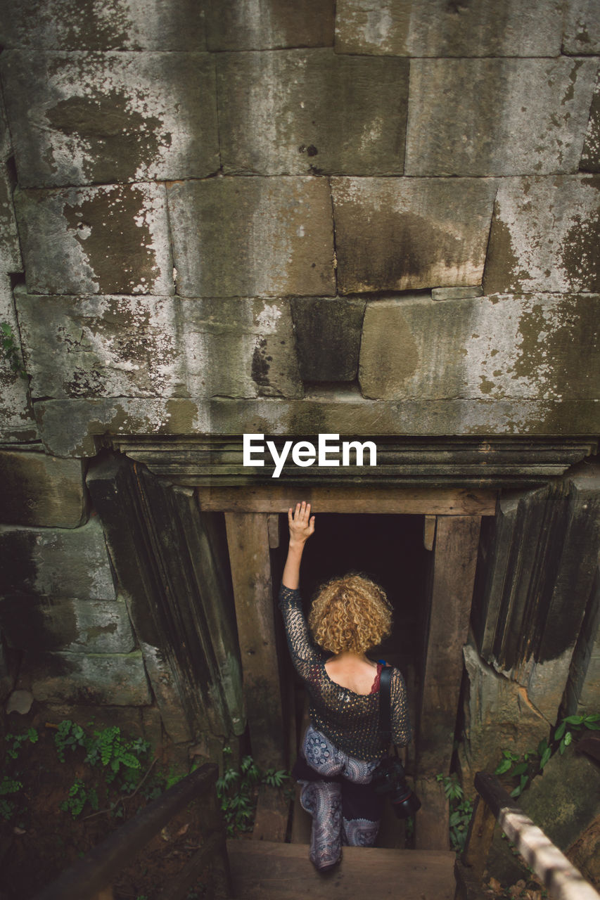 Rear view of woman entering in old ruin