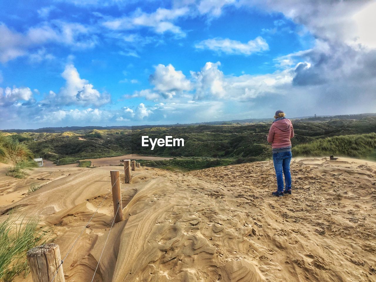 REAR VIEW OF MAN STANDING ON MOUNTAIN