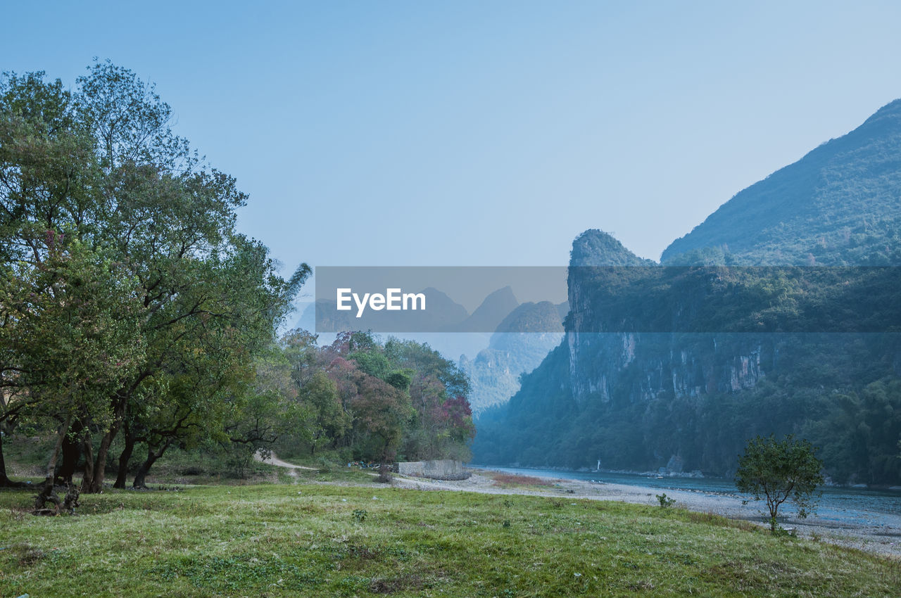 Scenic view of landscape and mountains against clear sky