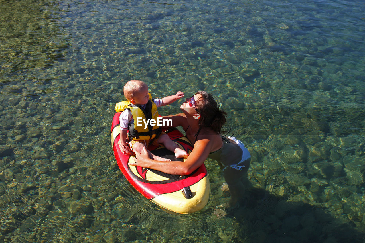 WOMAN SITTING ON BOAT IN WATER