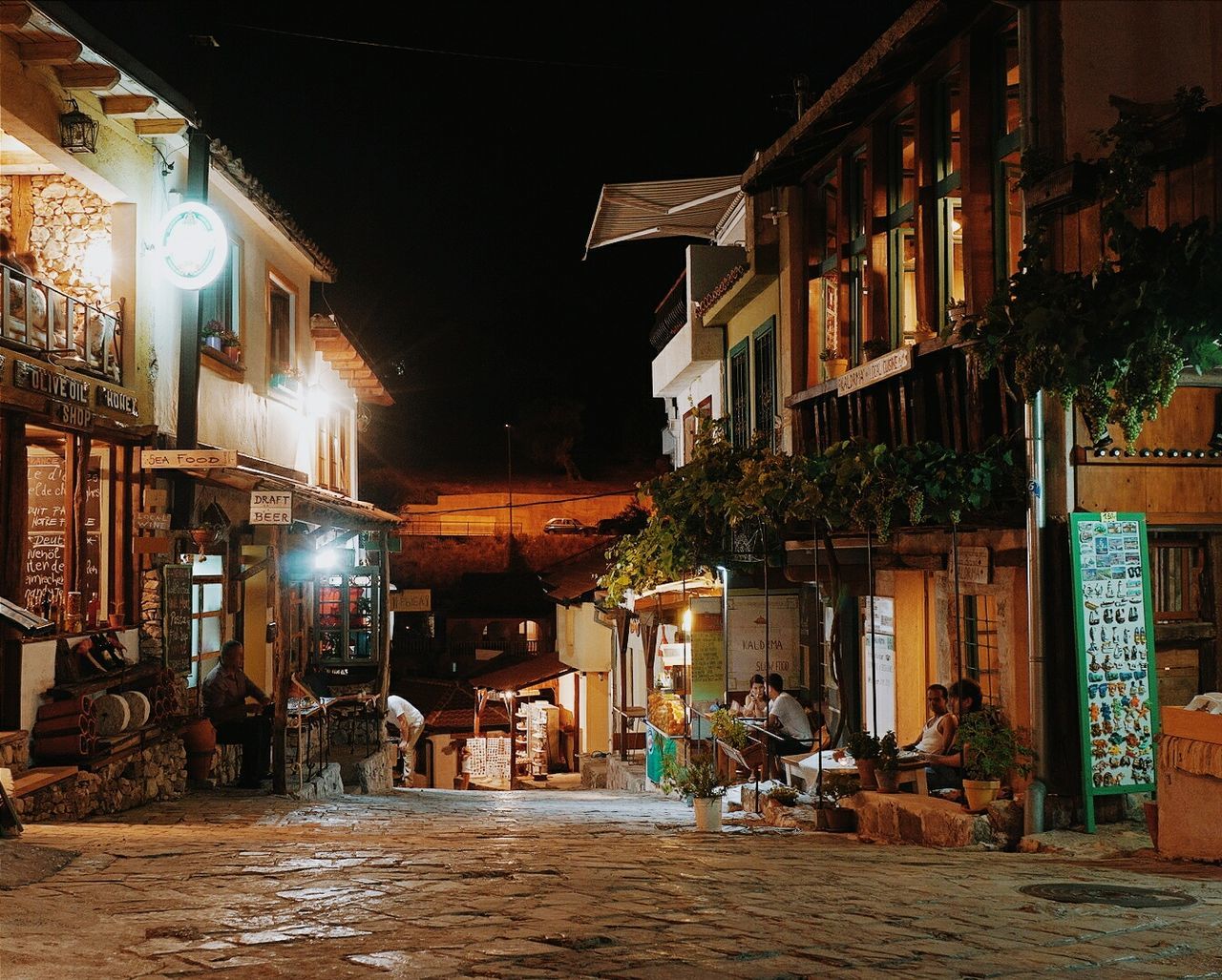 WALKWAY ALONG BUILDINGS AT NIGHT