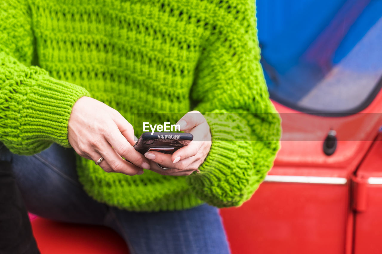 Midsection of woman using mobile phone