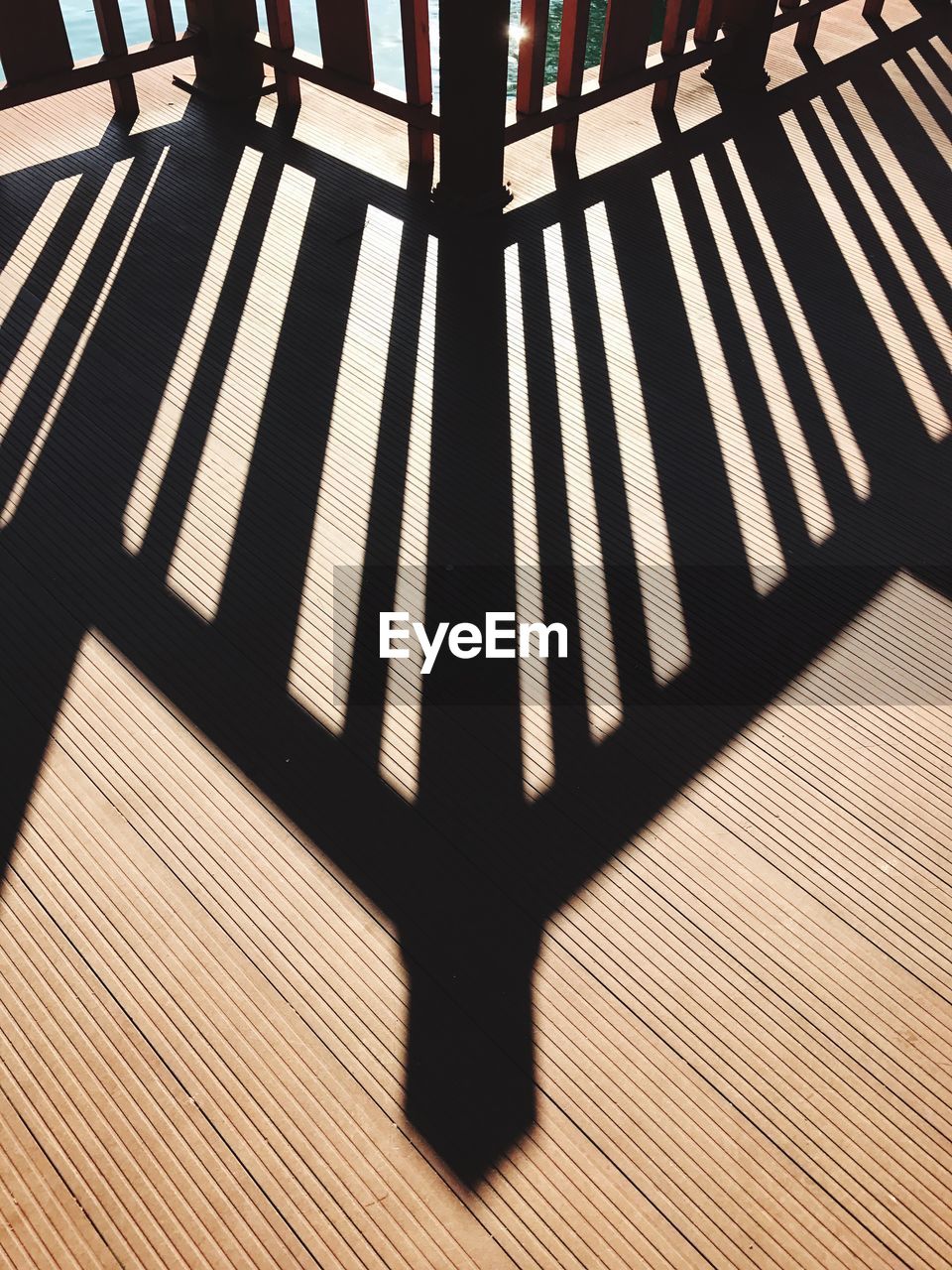 CLOSE-UP LOW SECTION OF SHADOW ON WOODEN FLOOR