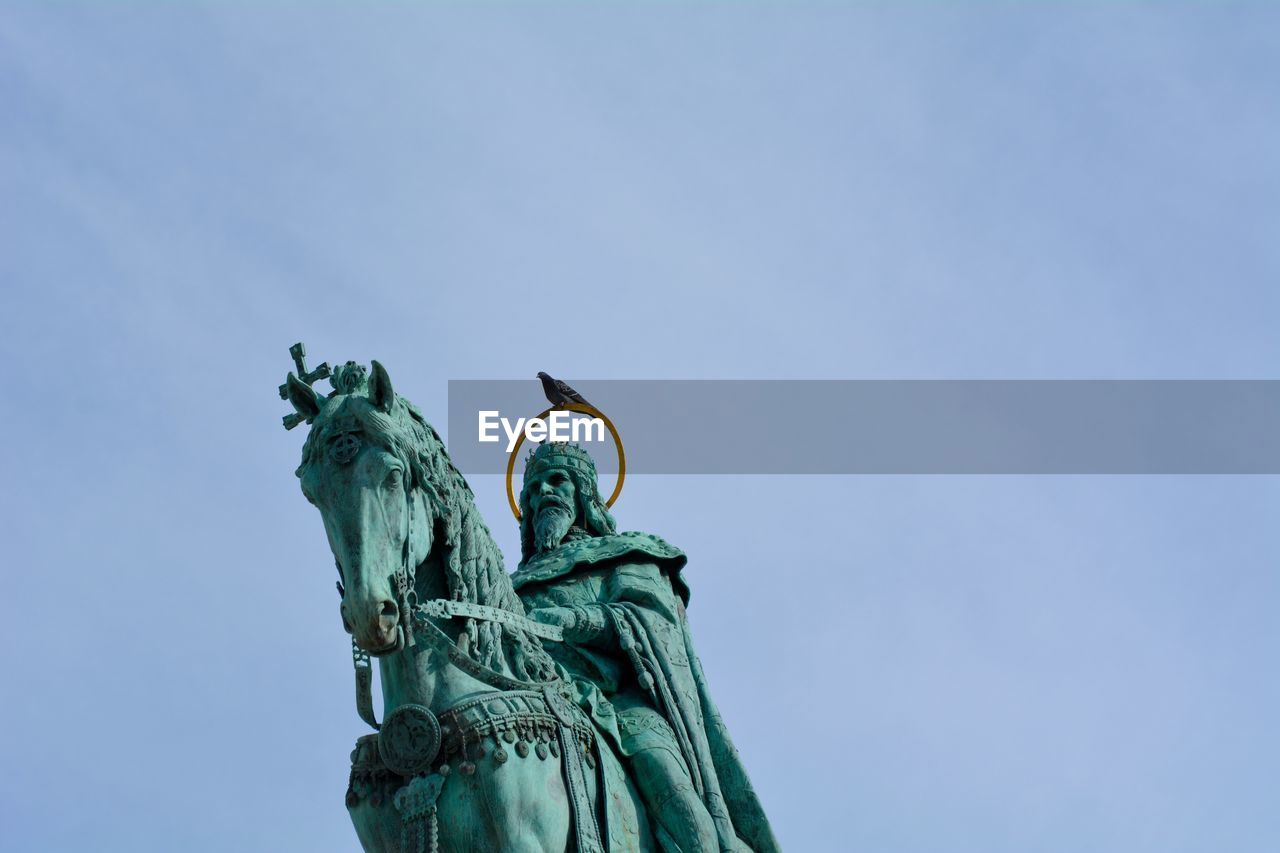 Low angle view of statue against blue sky