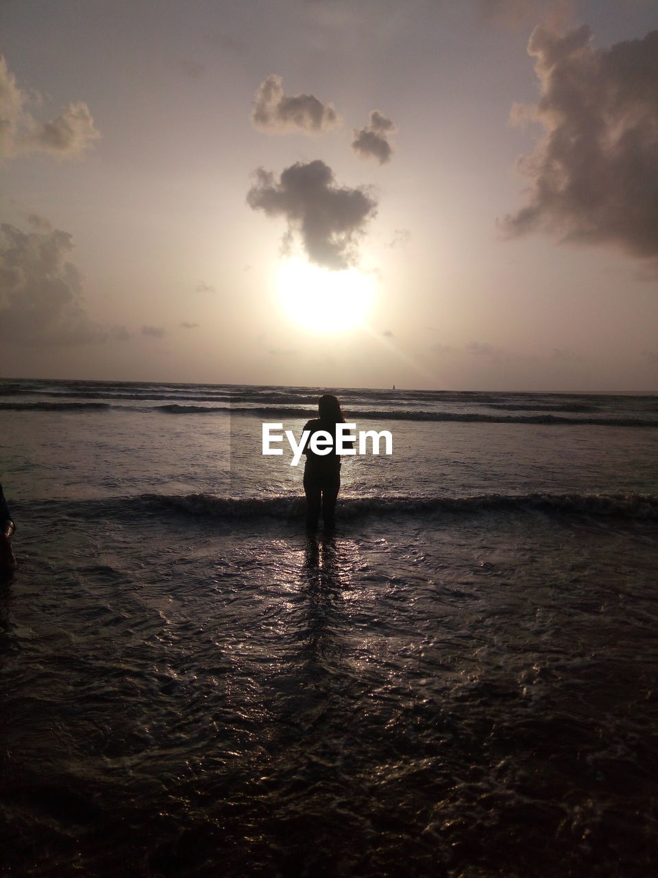 SILHOUETTE OF MAN STANDING ON BEACH AGAINST SKY