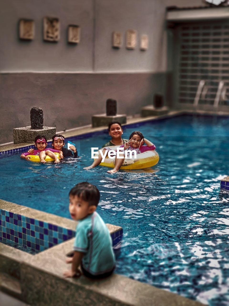 FULL LENGTH OF CHILDREN IN SWIMMING POOL AT NIGHT