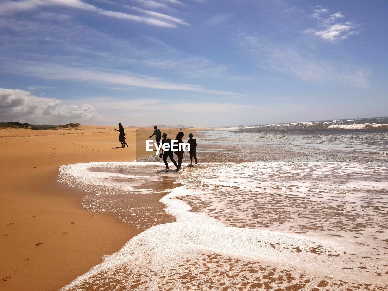 People at beach against blue sky