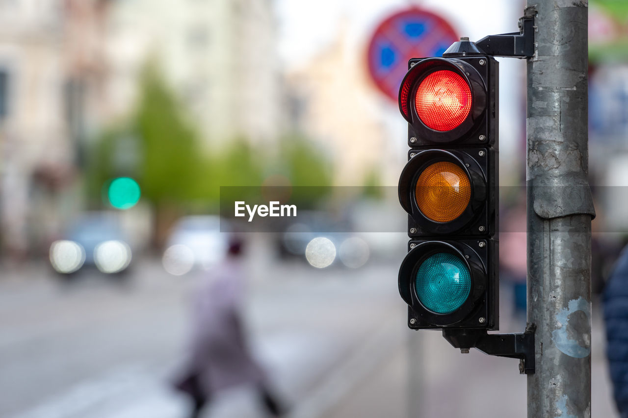 CLOSE-UP OF ROAD SIGNAL WITH TEXT ON STREET