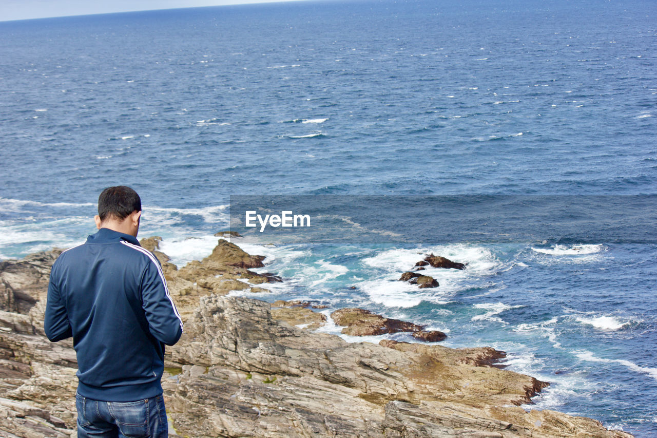 Rear view of man standing at beach