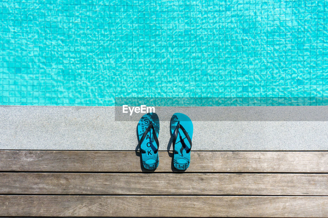 HIGH ANGLE VIEW OF SHOES ON POOL