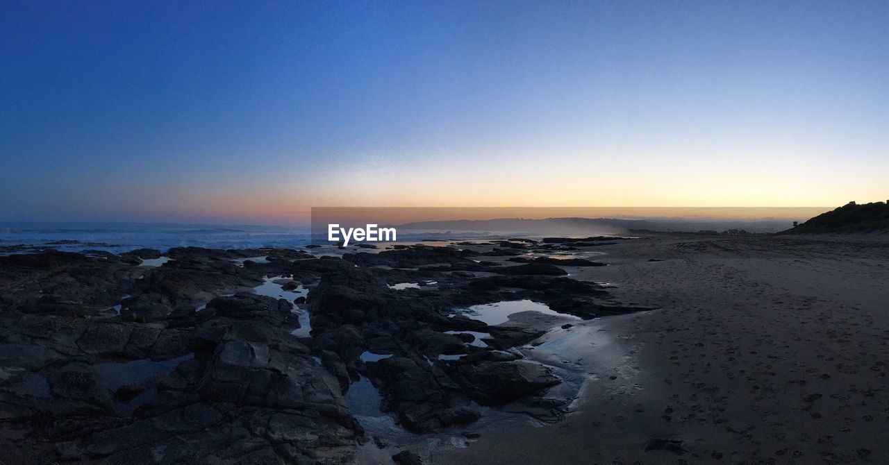 Scenic view of beach against clear sky