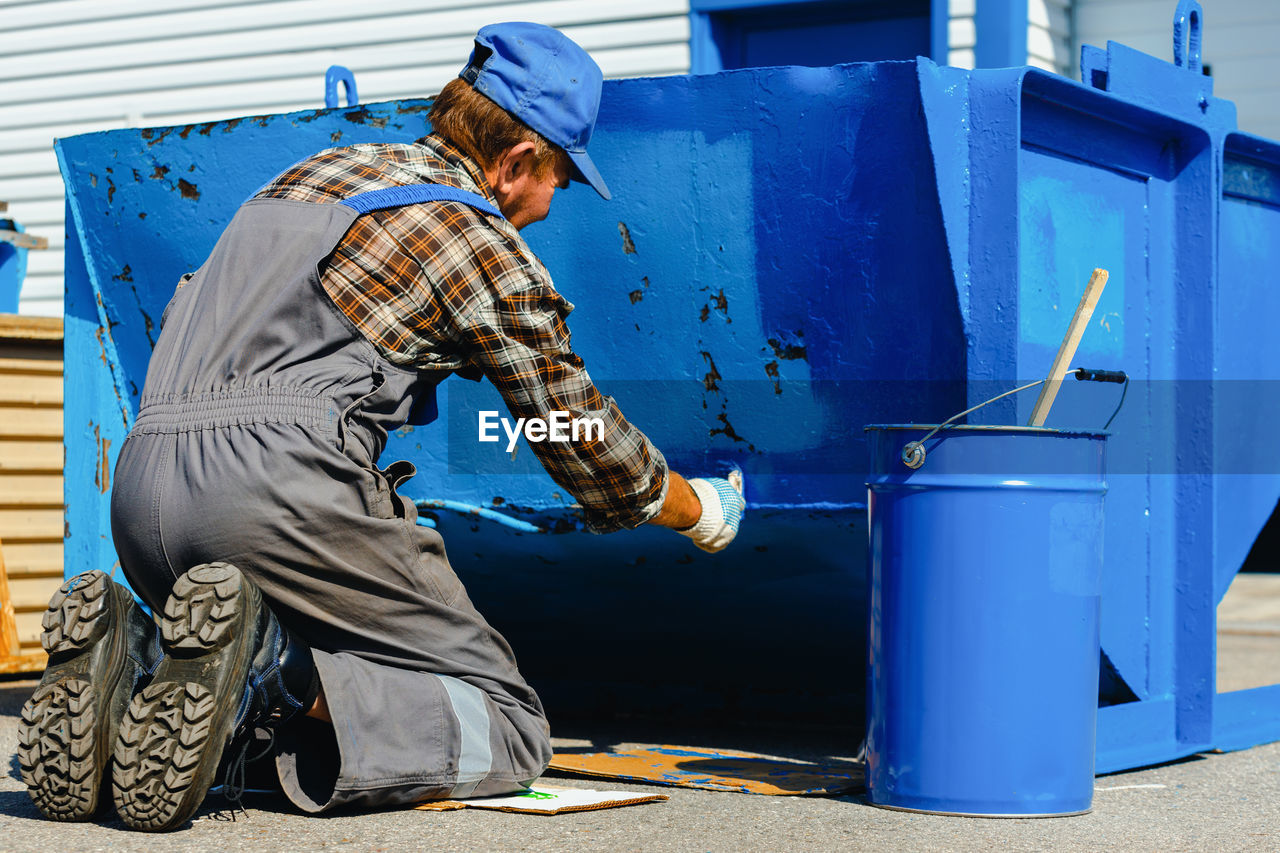 Man painting metal structure