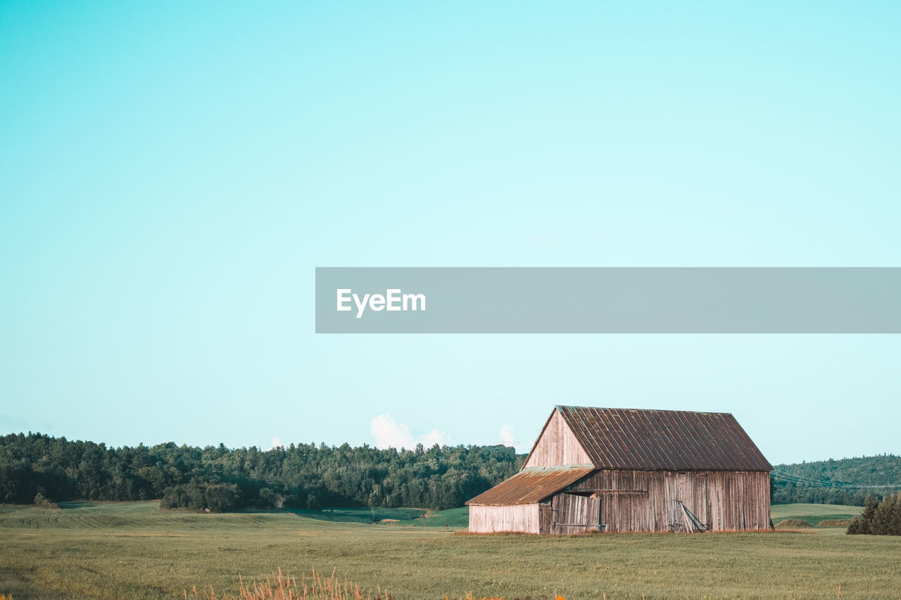 House on field against clear sky