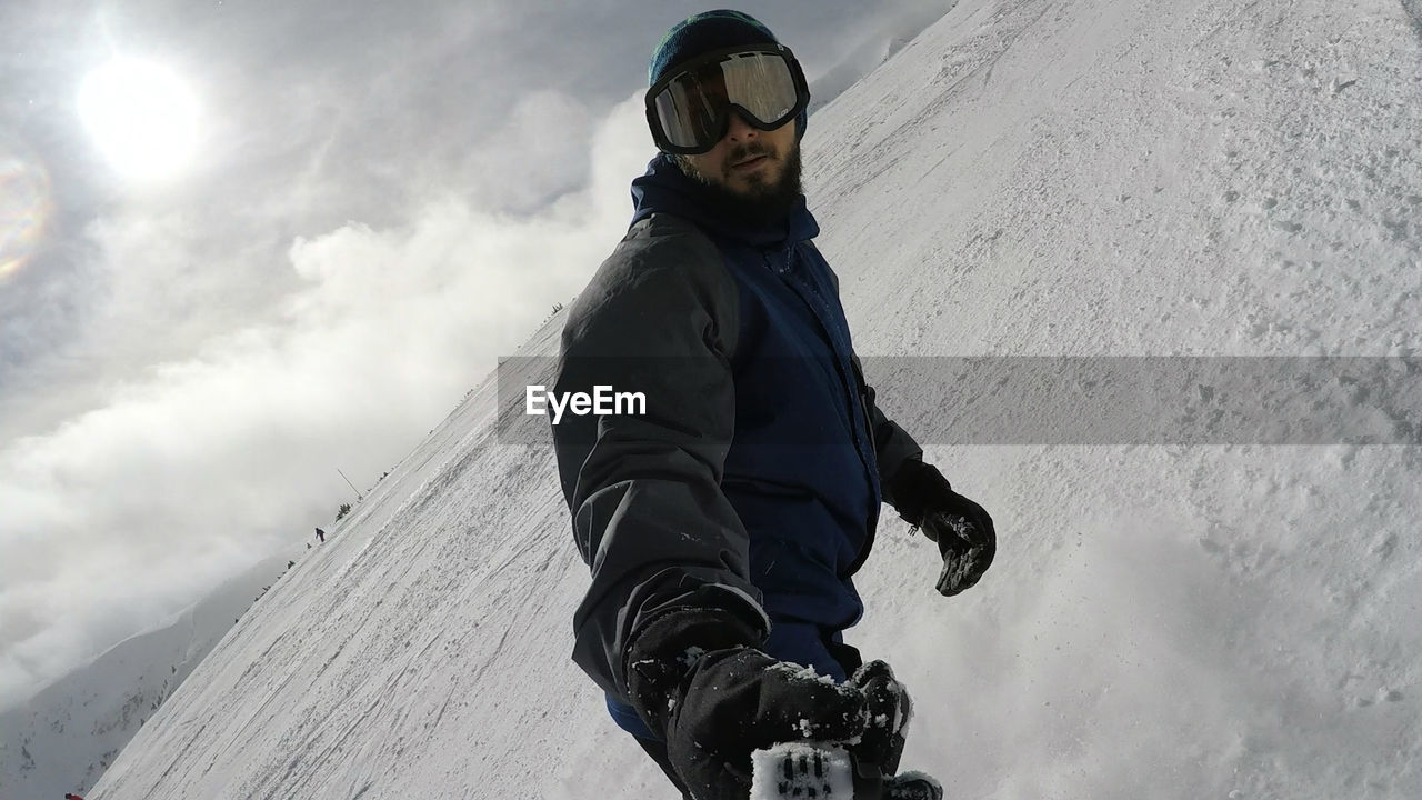 Low angle view of man on snow against sky