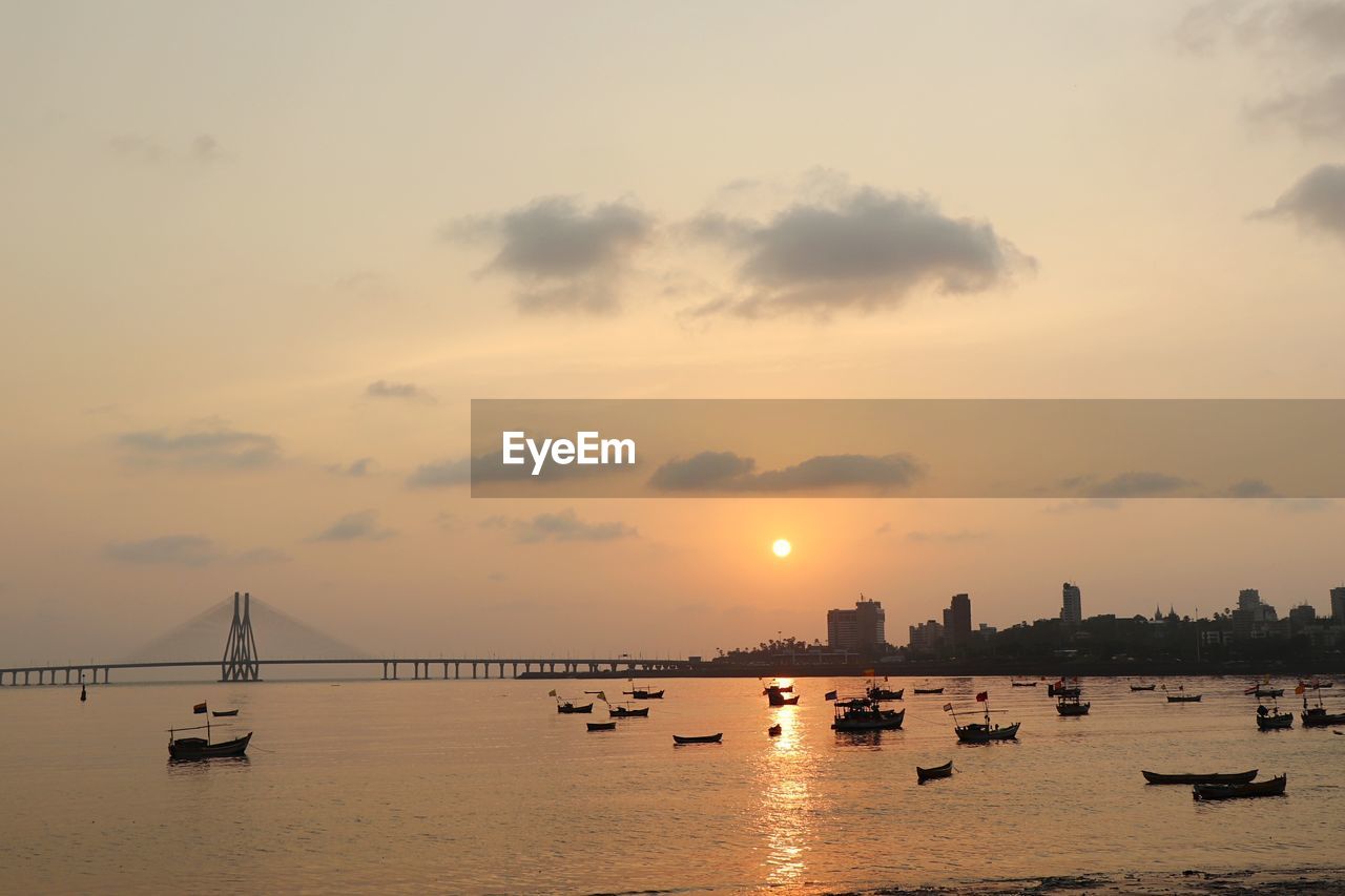 Silhouette of boats in sea during sunset