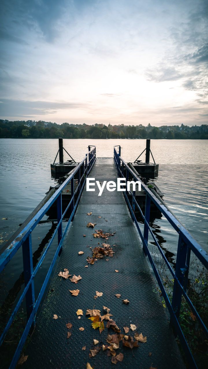 PIER OVER LAKE AGAINST SKY DURING SUNSET