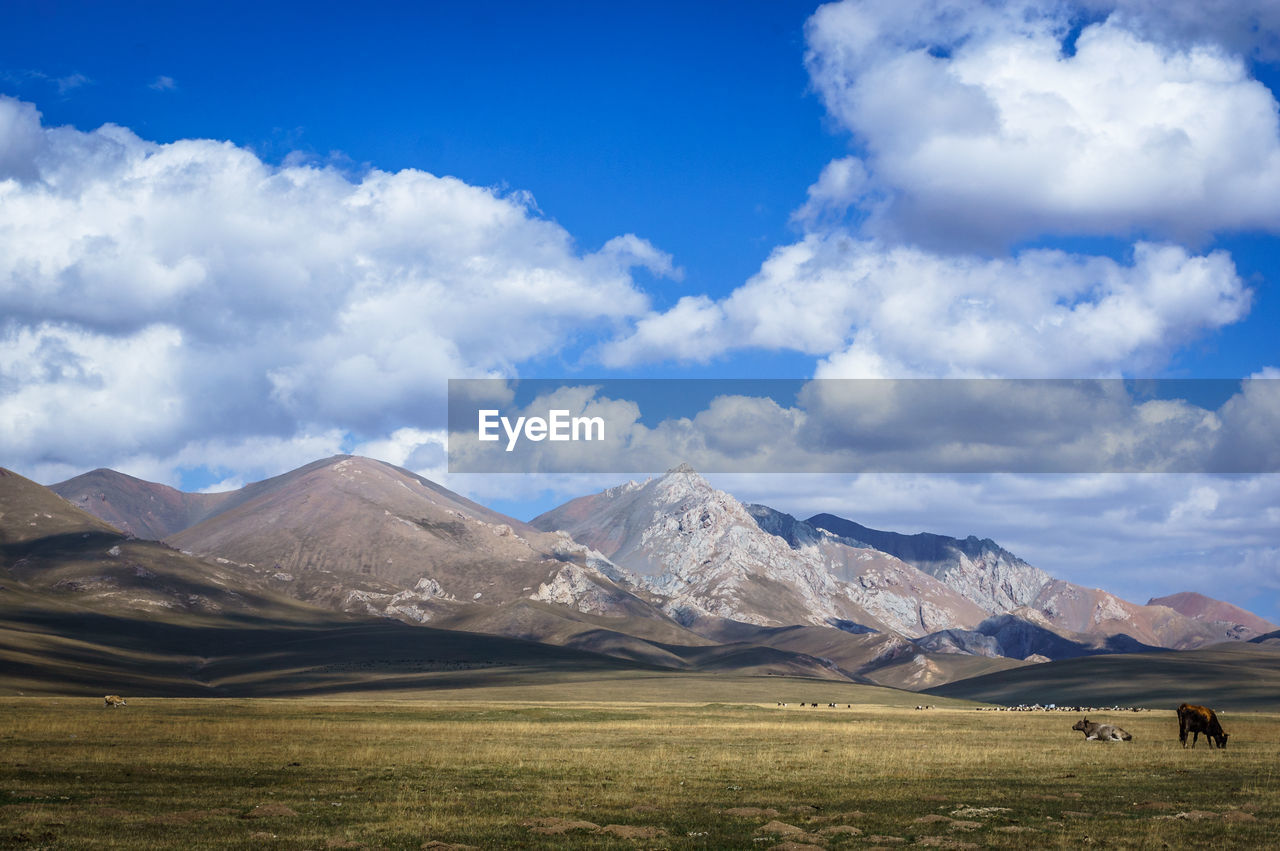 Scenic view of mountains against cloudy sky