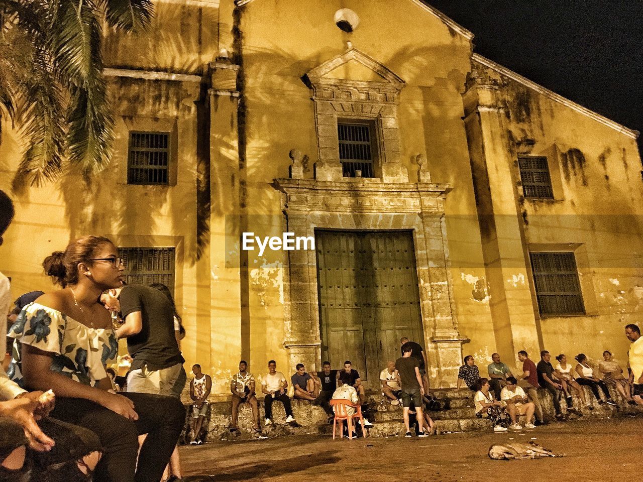 GROUP OF PEOPLE IN FRONT OF BUILDING AT NIGHT