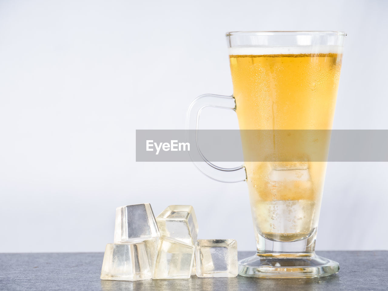 CLOSE-UP OF BEER GLASS ON TABLE