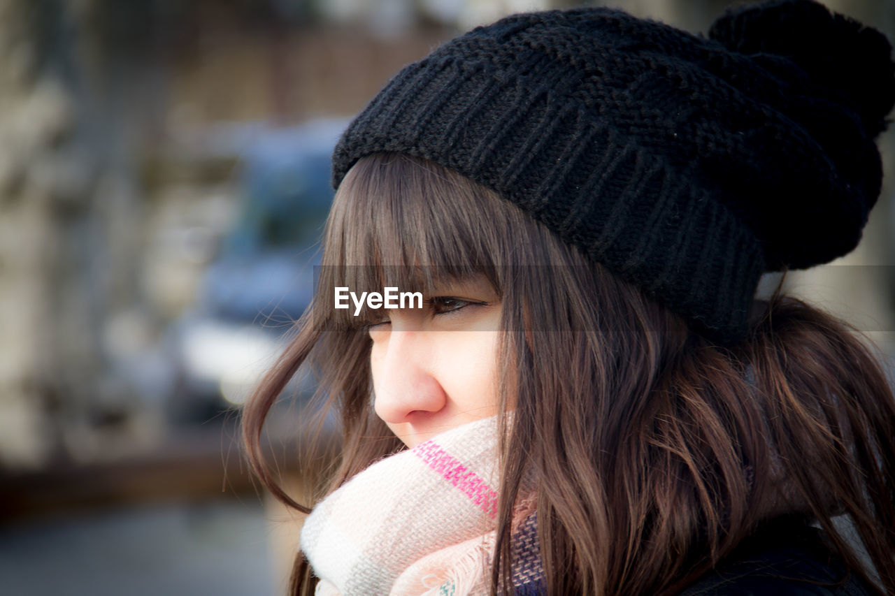 Close-up of woman in knit hat looking away