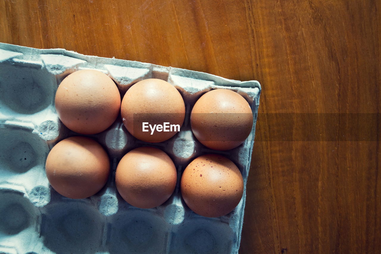 HIGH ANGLE VIEW OF EGGS IN CRATE ON TABLE